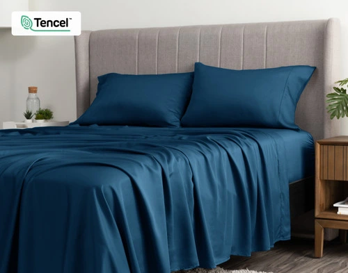 Angled view of a queen bed dressed in our BeechBliss TENCEL™ Modal Sheet Set in Seaport Blue.