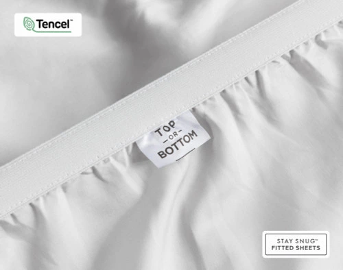 Close-up on the stretched elastic edge and tag stating "Top / Bottom" on our Eucalyptus Luxe TENCEL™ Lyocell Fitted Sheet in Silver.