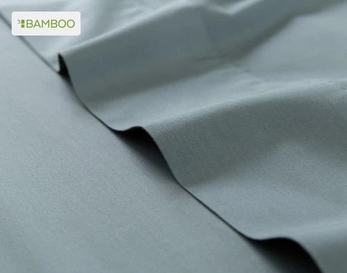 Flat sheet for our Bamboo Cotton Sheet Set in Spruce ruffled lightly over a matching smooth surface.