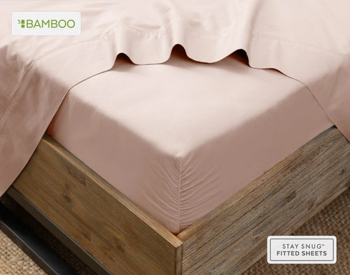 Flat sheet draped over our Bamboo Cotton Fitted Sheet in Blush Pink around the corner of a mattress.