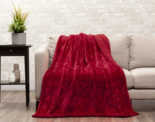 Front view of our Diamond Etched Throw in Ruby draped over the seat of a couch.