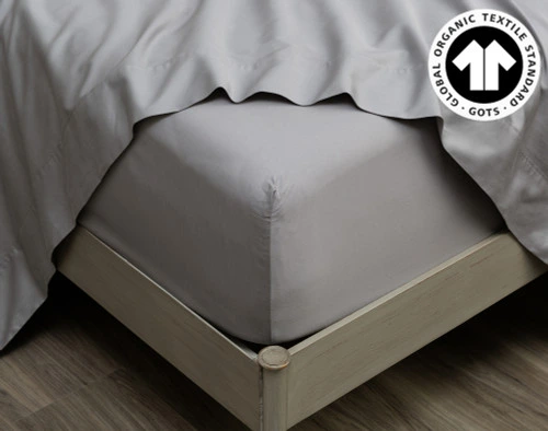 Close-up on the corner of our Organic Cotton Fitted Sheet in Sleet wrapped around a mattress.