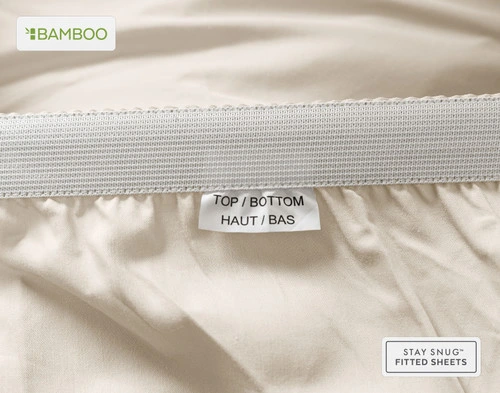 Edge of our Bamboo Cotton Fitted Sheet in Driftwood Beige to show a tag stating "Top" and "Bottom."