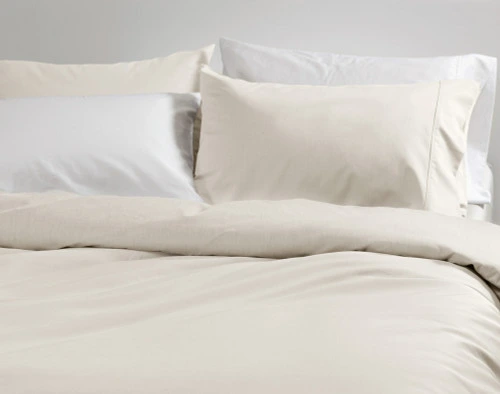 Close-up on the soft fabric over the surface of our Bamboo Cotton Duvet Cover in Driftwood, a light cloudy beige.