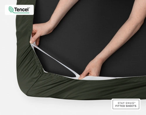 Underside of our BeechBliss TENCEL™ Modal Fitted Sheet in Rainforest Green to show its stay snug elastics being pulled by two hands.