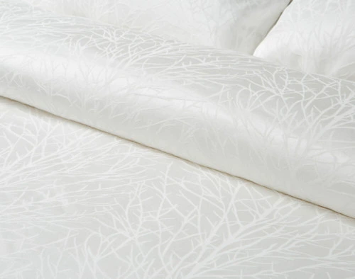 Close-up of our Blanchard White Duvet Cover to show its jacquard pattern on its softly folded fabric.