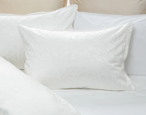 Our Blanchard White Pillow Sham on white bedding.