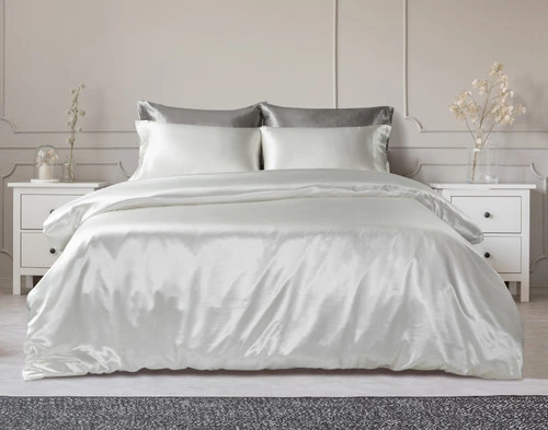 Our Silk Duvet Cover in Snow dressed over a classic bed in a white bedroom.