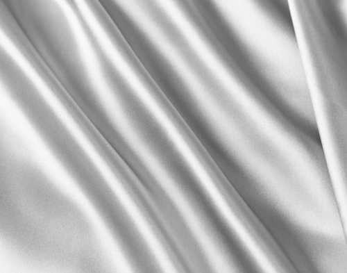 Close-up of bunched up silk fabric on our Silk Duvet Cover in Silver to show its shine and softness.