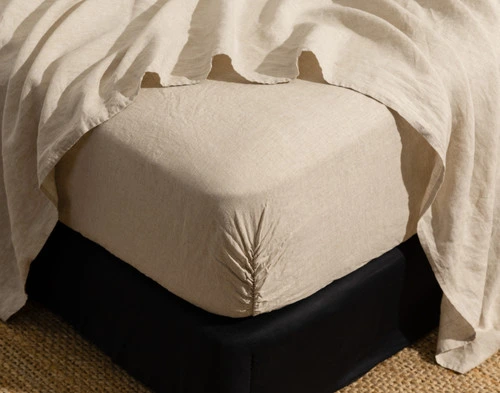 Corner of our Signature European Linen Fitted Sheet in Natural fit snugly around a mattress.