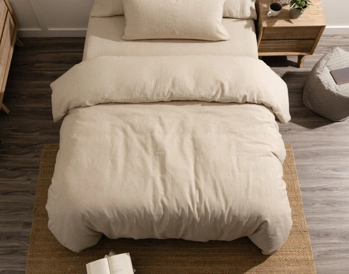 Top view of our Signature European Linen Duvet Cover in Natural dressed over a queen bed with a centered queen-sized pillow by the head.