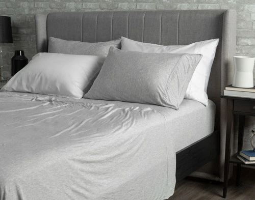 Angled view of our Bamboo Jersey Sheet Set in Grey dressed over a queen bed.