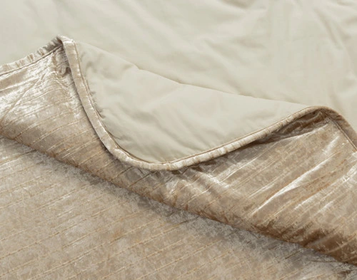 Folded corner on our Avalon Quilt Set in Champagne Gold to show its textural surface and solid cotton backing together.