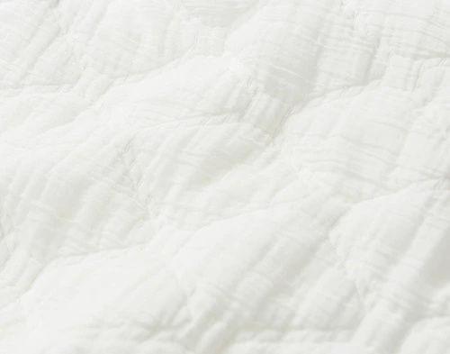 Close-up on the textural white cotton fabric on our Cavell White Cotton Quilt Set.