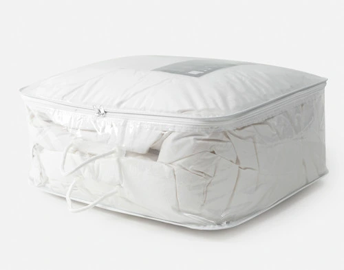 Our Duvet Storage Bag leaning on its side with a duvet stored snugly inside.