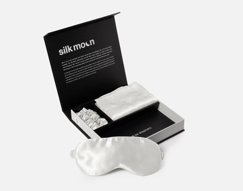 Angled view of our unboxed Mulberry Silk Gift Set in Snow featuring a silk eye mask, pillowcase, and scrunchie.