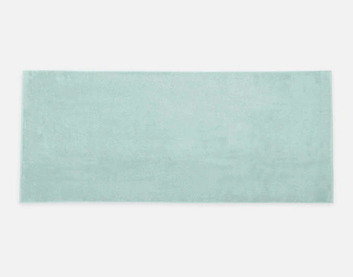 Top view of our Modal Cotton Bath Sheet in Seafoam laying flat over a solid ground.