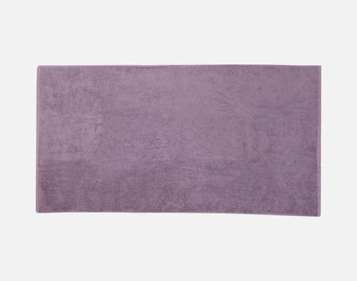 Top view of our Modal Cotton Bath Towels in Lilac Ash laying flat over a solid ground.