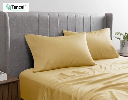 Angled view of our BeechBliss TENCEL™ Modal Pillowcases in Sun Shower resting against a grey headboard.