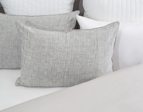 Front view of our Landon Pillow Sham resting against coordinating white pillows.