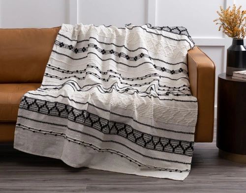 Our Artisanal Throw in Kavi draped over a couch.