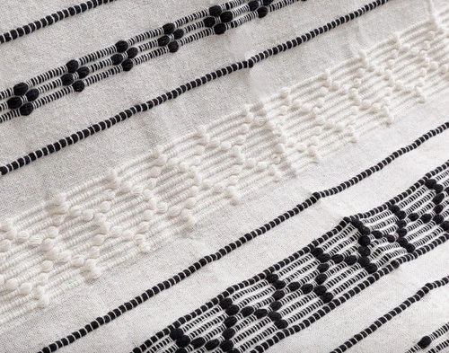 Close-up on the hand woven line pattern on our Artisanal Throw in Kavi.