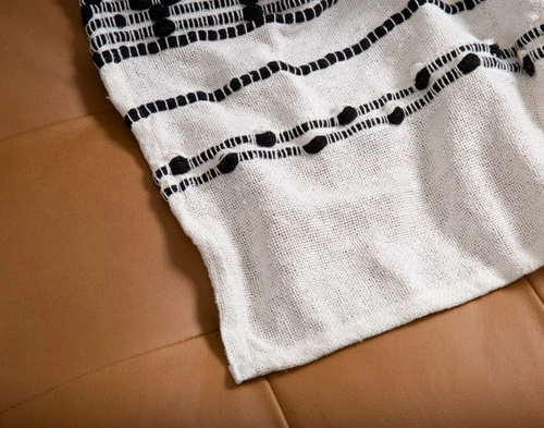 Close-up on the hemmed border corner on our Artisanal Throw in Kavi.