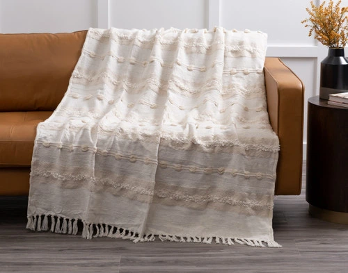 Our Artisanal Throw in Naya draped over a couch.