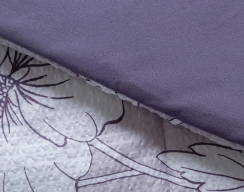 Folded edge on our Tessa Recycled Polyester Comforter Set to show its patterned surface and solid reverse side-by-side.