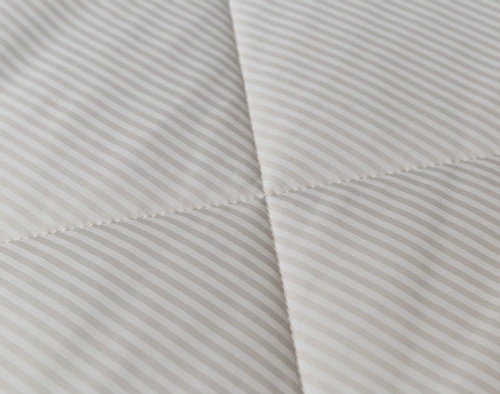 Close-up on the light and dark stripes on our Cool Touch Blanket in Ash Stripe and its diamond top-stitching.