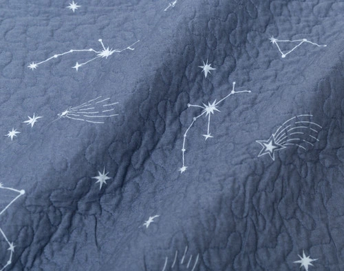 Close-up on the light blue starry sky reverse on our Solar System Cotton Quilt Set.