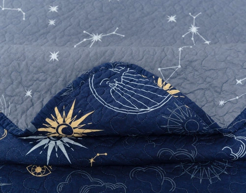 Folded corner on our Solar System Cotton Quilt Set to show its face and reverse patterns together.