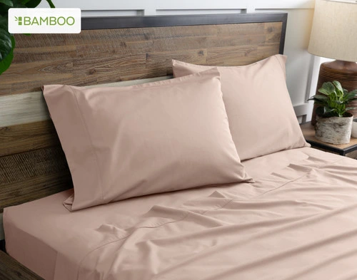 Two of our Bamboo Cotton Pillowcases in Frosted Berry Pink resting on a wooden bed with coordinating sheets.