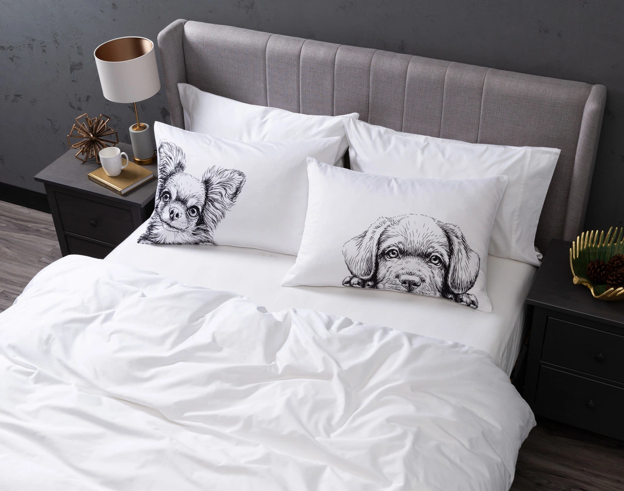 Angled view of our Dogs Pillow Talk Pillowcases sitting on a white bed in a dark grey bedroom.