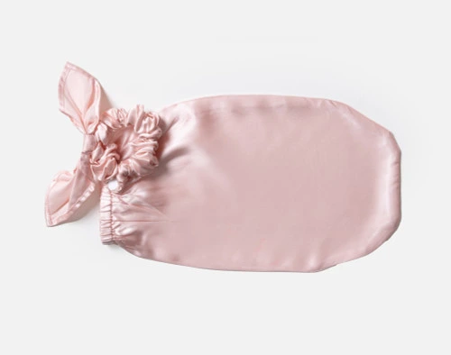 Front view of our Mulberry Silk Bun Cover in Blush sitting empty over a solid white background.