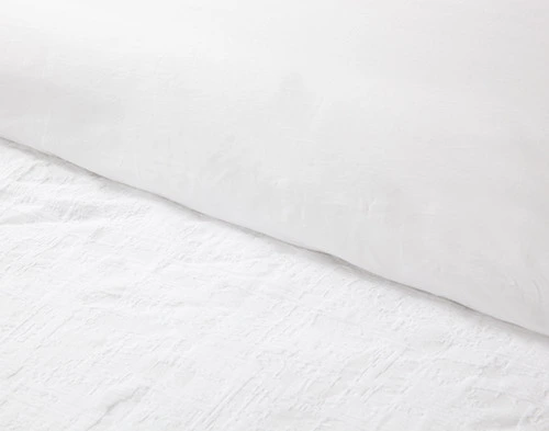 Close-up on the folded top edge of our Chalkstone Duvet Cover to show its surface and reverse fabrics together.