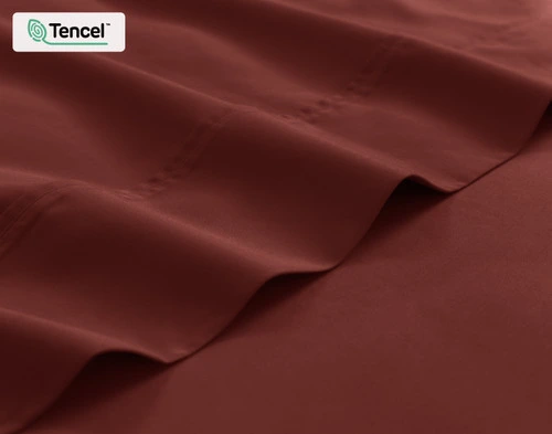 Close-up on the edge of the flat sheet for our Eucalyptus Luxe TENCEL™ Lyocell Sheet Set in Maroon.