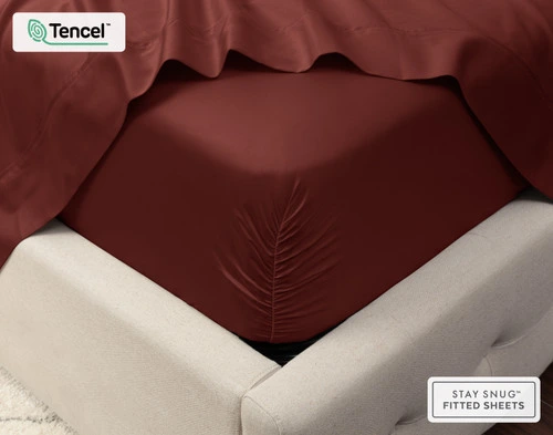 Close-up on the corner of a mattress with our Eucalyptus Luxe TENCEL™ Lyocell Fitted Sheet in Maroon to show its snug fit.