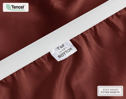 Close-up on the stretched elastic edge and tag stating "Top / Bottom" on our Eucalyptus Luxe TENCEL™ Lyocell Fitted Sheet in Maroon.