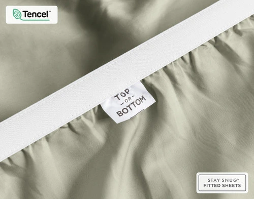 Close-up on the stretched elastic edge and tag stating "Top / Bottom" on our Eucalyptus Luxe TENCEL™ Lyocell Fitted Sheet in Mistywoods.