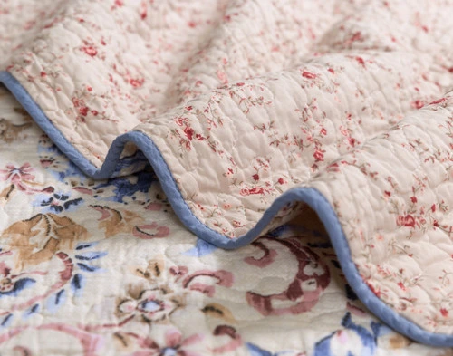 Ruffled edge of our Misha Cotton Quilt Set to show the pale blue hemmed border.