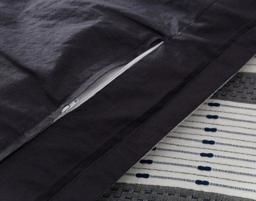 Close-up on the zipper enclosure and dark charcoal organic cotton reverse on our Dash Duvet Cover.