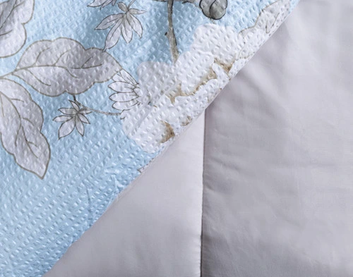 Folded edge of our Jules Comforter Set to show its patterned surface and solid reverse.