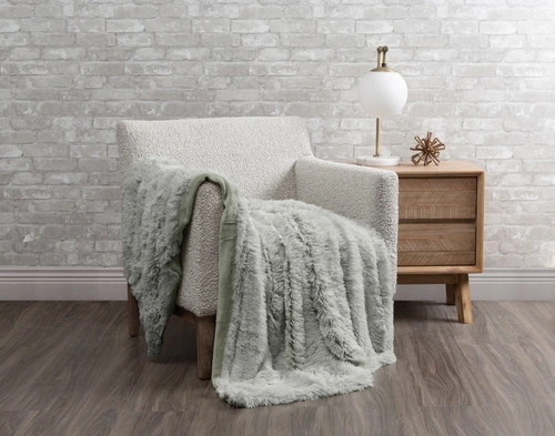 Our Frosted Shaggy Throw in Mistywoods draped over a chair in a white room.