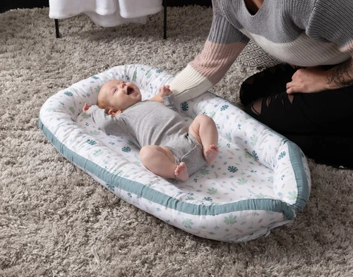 Top view of our Baby Nest Bed in Teal with a baby 