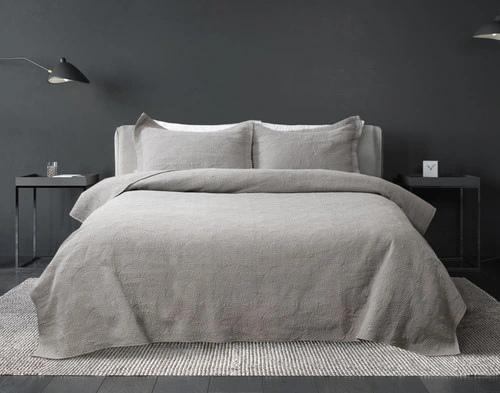 Front view of our Elden Cotton Quilt Set dressed over a queen bed in a dark grey bedroom.