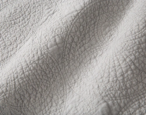 Close-up on the textured medallion pattern and stone-like texture on our Elden Cotton Quilt Set.