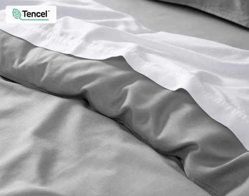 Close-up on our Hemp Touch Duvet Cover in Grey dressed with white sheeting.