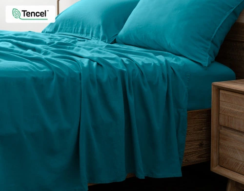 Side view of our Hemp Touch Sheet Set in Lake Blue to show its flat sheet draping over its side.