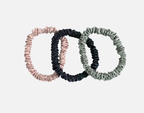 Our 100% Mulberry silk scrunchies in Frosted Berry Pink, Black, and Mistywoods Green resting against a solid white background.